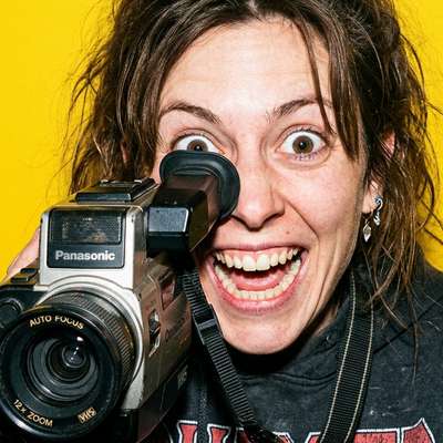 A manic filmmaker peering through a video camera, representing the search for top London video agencies.