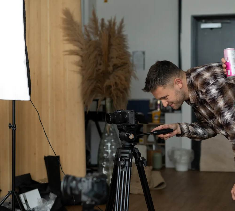 A video production crew setting up lights and a camera around an interview chair in a modern UK office, representing the real costs behind corporate video production.