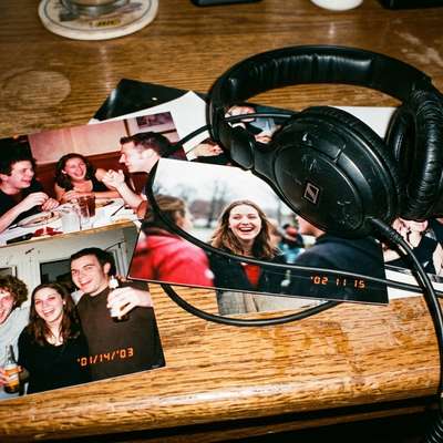 Candid photos of people on a table with headphones, representing the actual listeners behind podcast audience data.