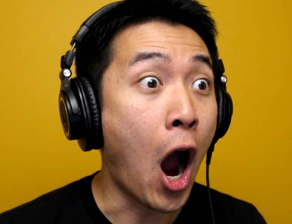 Man wearing studio headphones with a shocked expression, representing game-changing podcast production tips.